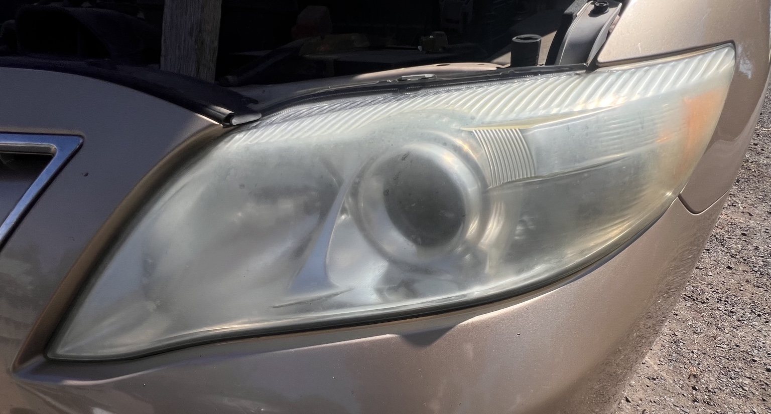 Close-up of oxidized Toyota Camry headlight before restoration